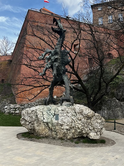 pomnik Smok wawelski w Krakowie na skale na tle Zamku